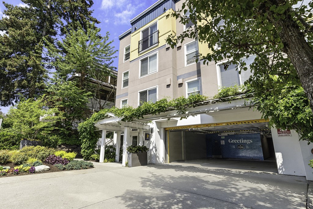 a large apartment building with a parking lot in front of it a large apartment building with a parking lot in front of it at Sir Gallahad Apartment Homes,  Bellevue, 98004